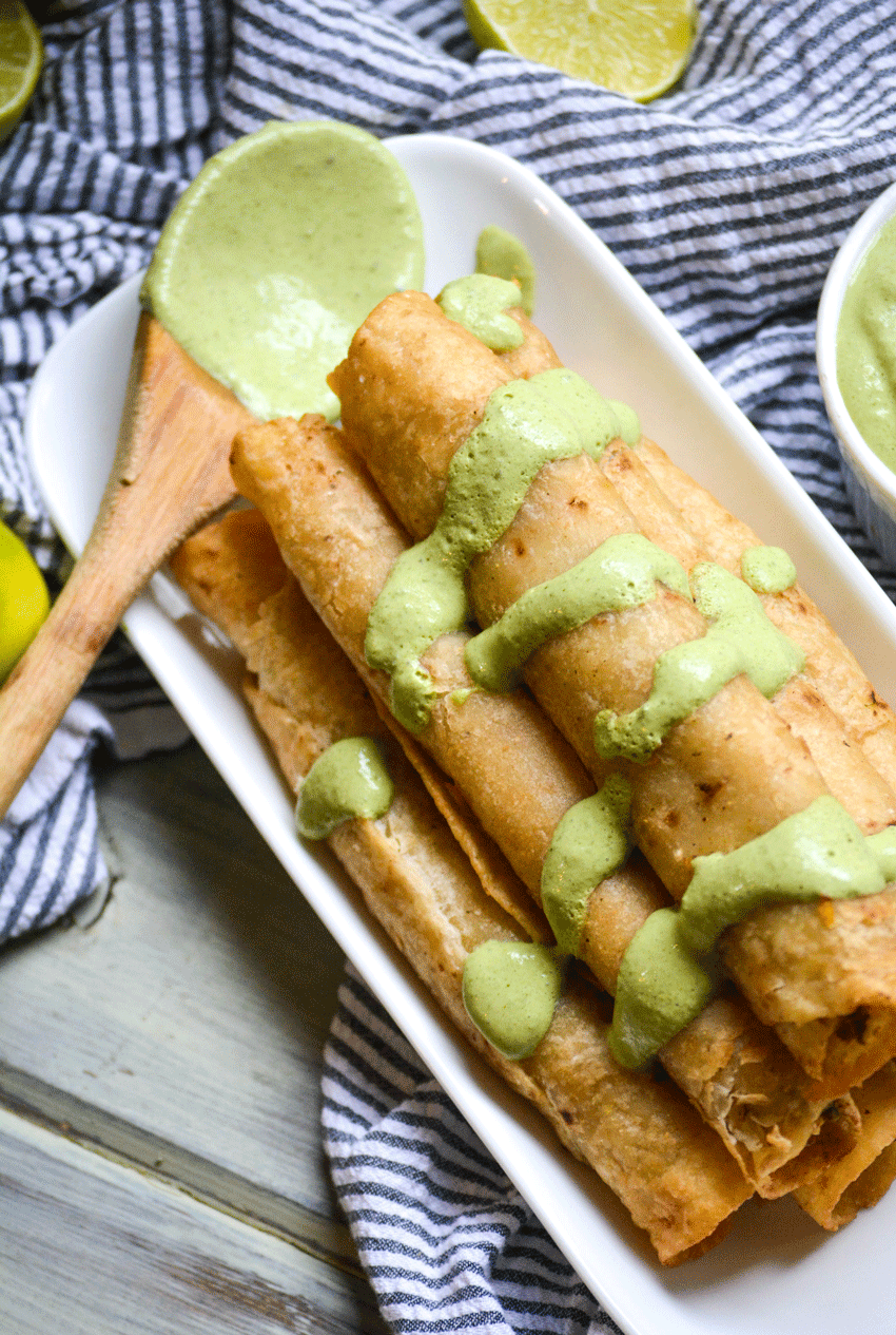 smoked cilantro cream sauce drizzled over a stack of fried flautas