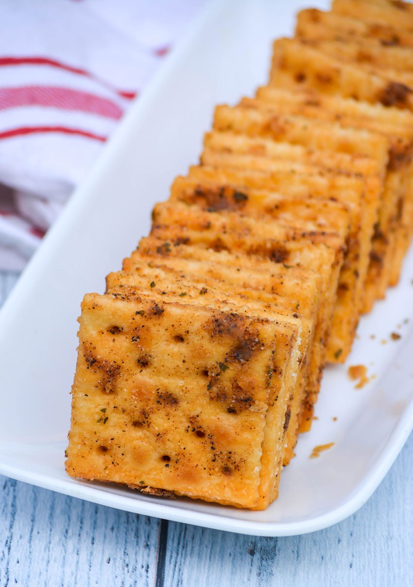 smoked saltine crackers arranged in a row on a small white platter