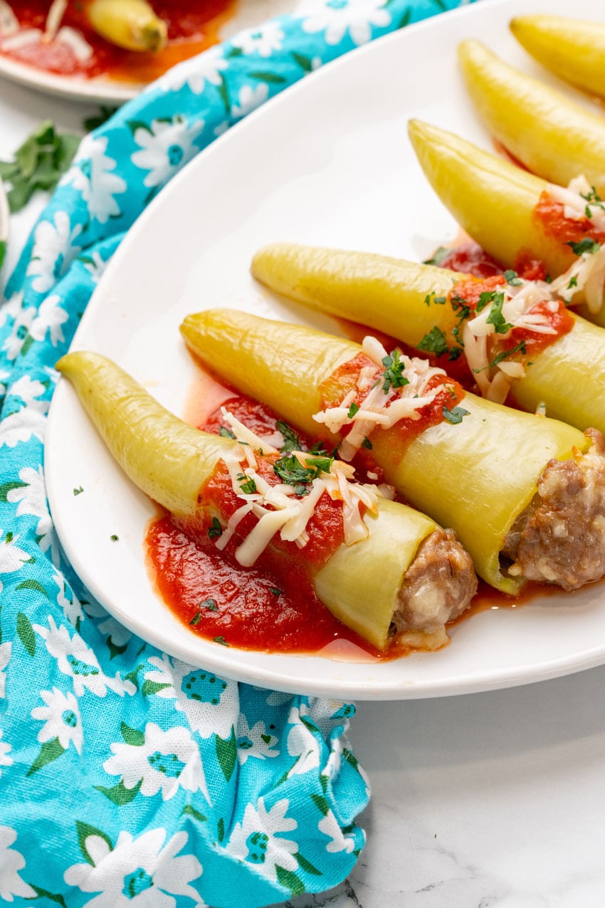sausage stuffed banana peppers on a white serving platter