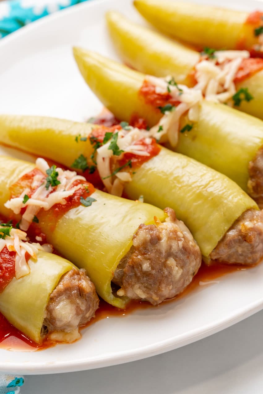 sausage stuffed banana peppers on a white serving platter