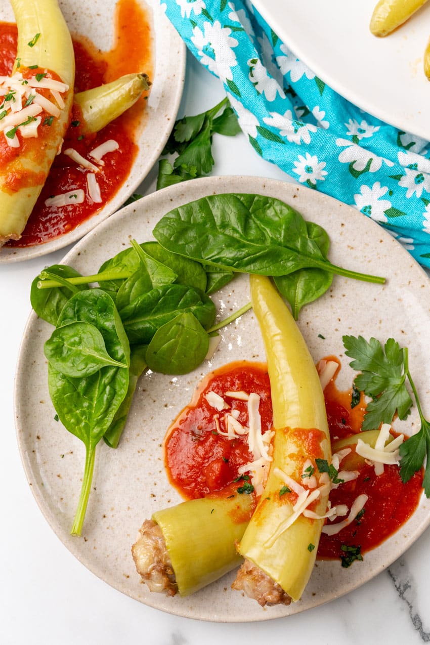 sausage stuffed banana peppers on a white serving platter