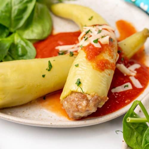 sausage stuffed banana peppers on a white serving platter