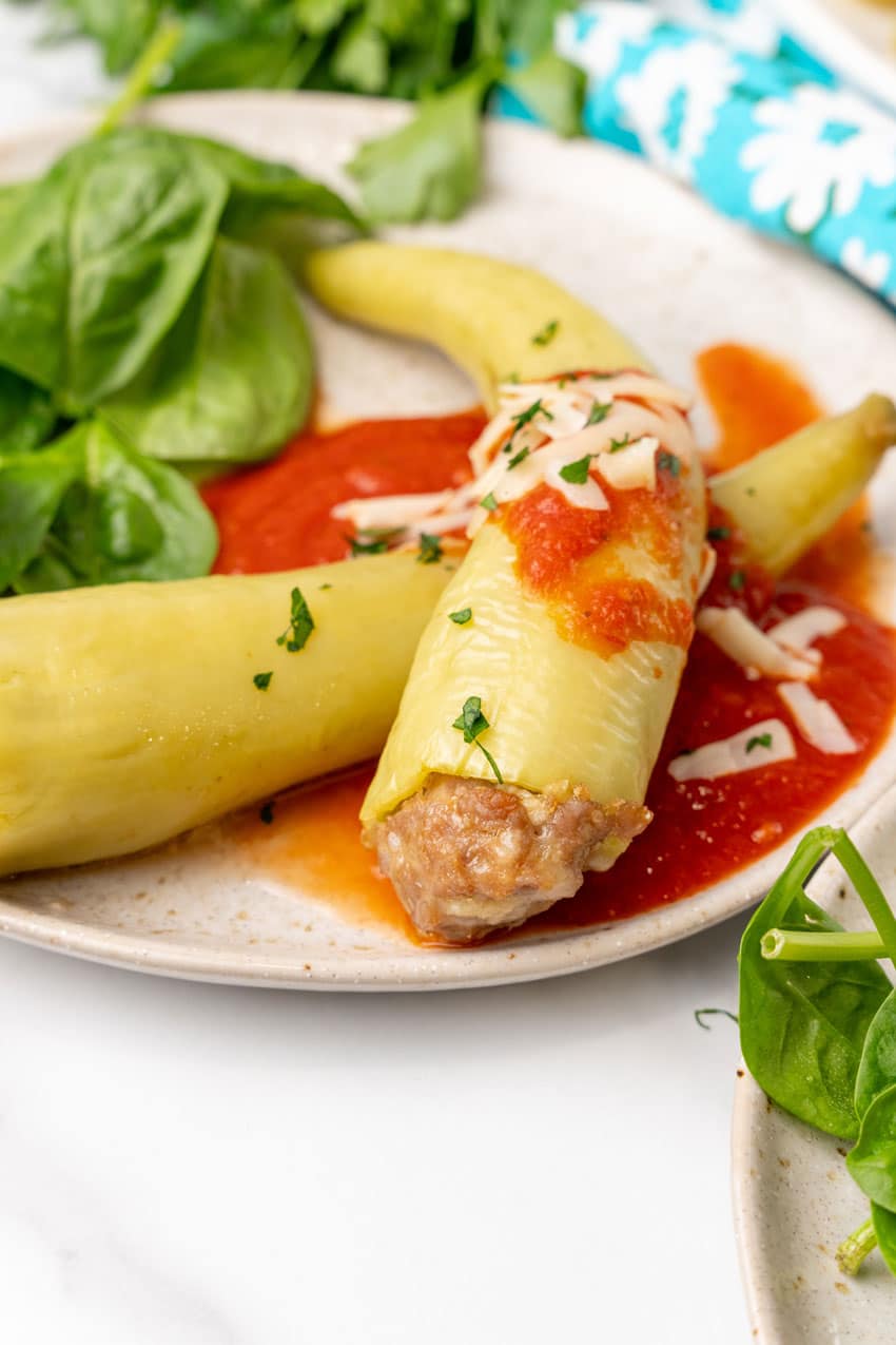 sausage stuffed banana peppers on a white serving platter
