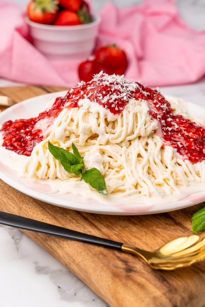 spaghetti eis served on a white plate with a sprig of mint leaves for garnish