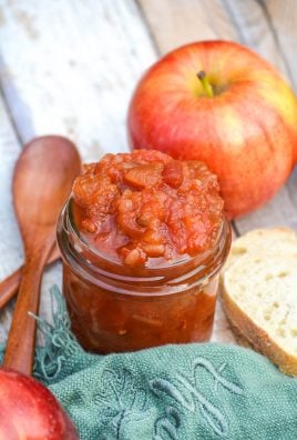 apple salsa in a small glass jar with a wooden spoon on the side