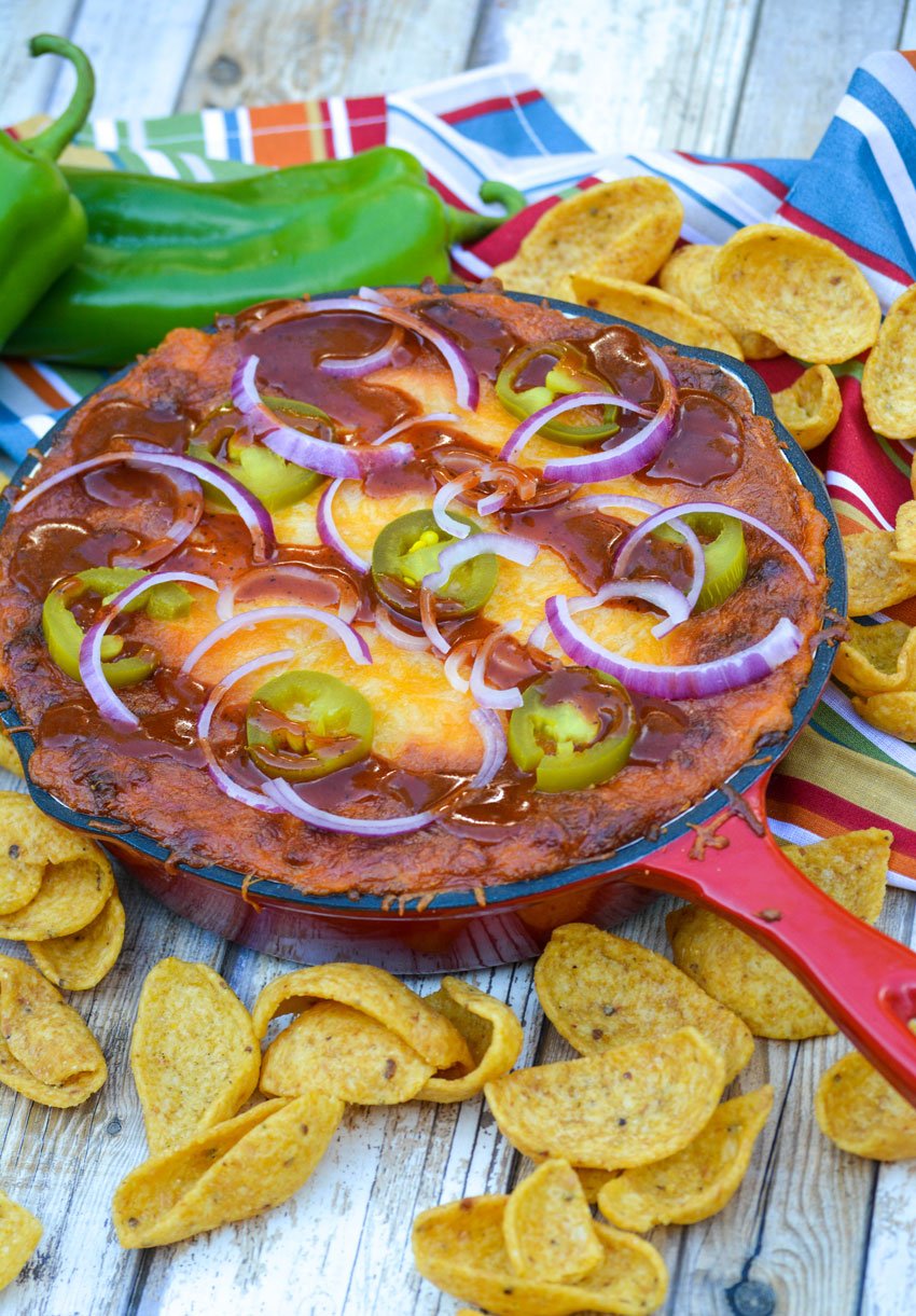 cheesy barbecue sauce topped pulled pork dip in a red enameled cast iron skillet