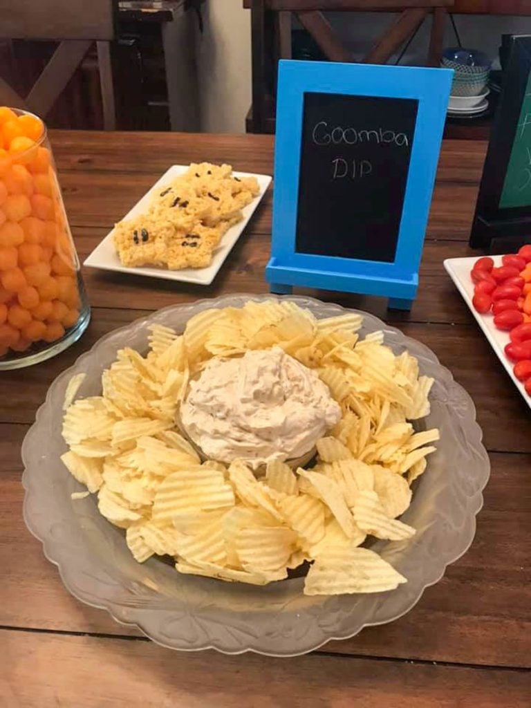 chalk board sign labeled goomba dip in front of a chip platter with french onion dip