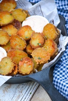 crispy parmesan crusted potatoes in a cast iron skillet with small white bowls of dip