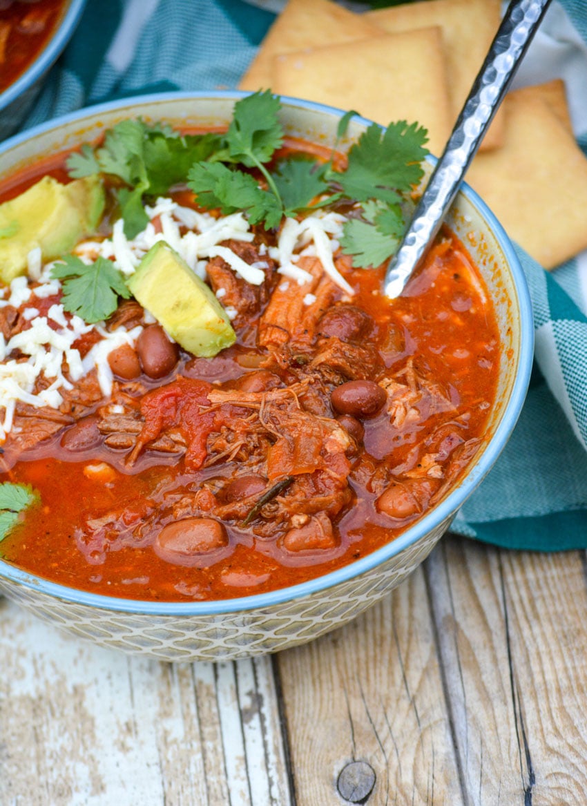 a silver spoon stuck in a bowl of crockpot pulled pork chili