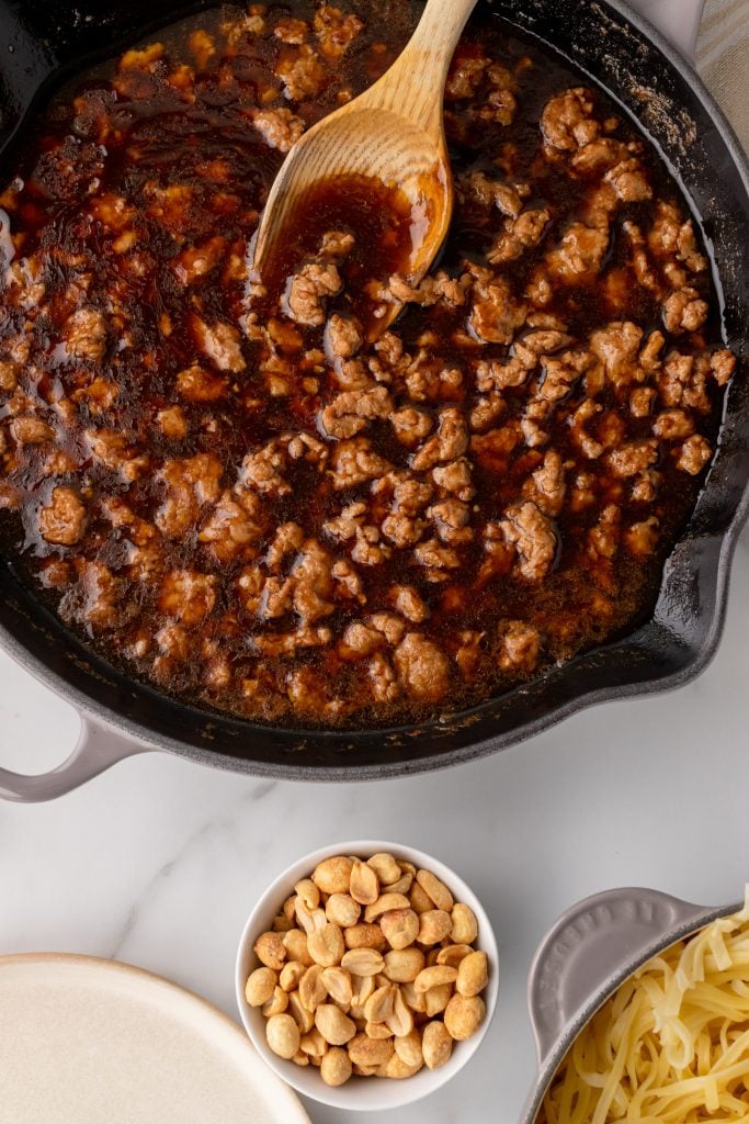 a skillet filled with cooked ground chicken in a thick brown sauce