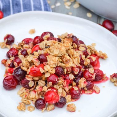 cranberry crisp with oatmeal crumble topping on a white plate