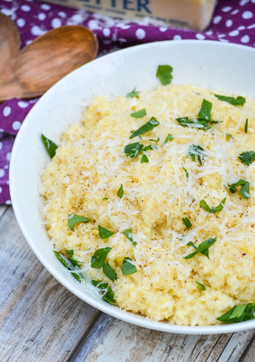 Nonna's Italian pastina in a white bowl topped with fresh herbs and shaved parmesan cheese