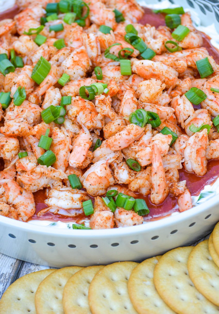 shrimp cocktail dip sprinkled with thinly sliced green onion with crackers on the side