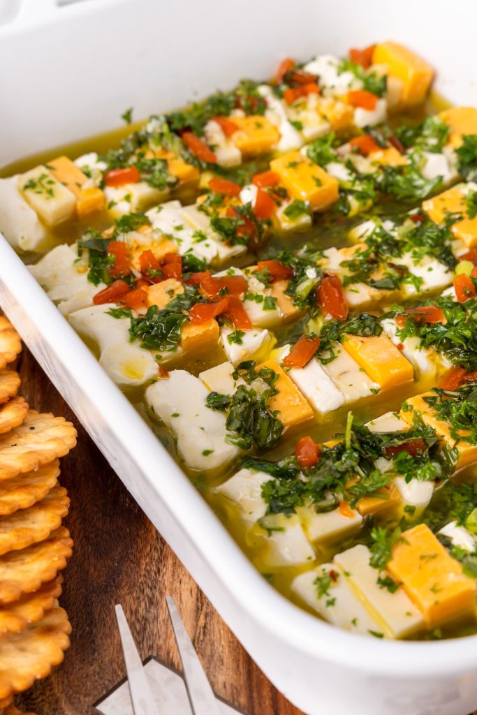 marinated cheese appetizer in a white casserole dish
