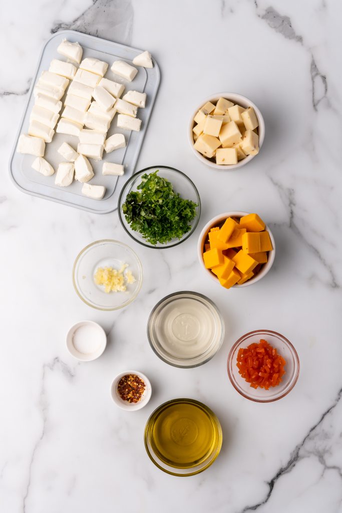 an overhead image showing the measured ingredients needed to make a marinated cheese appetizer