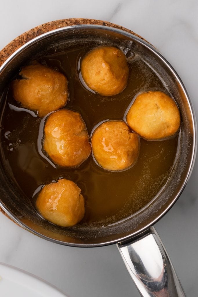 Italian struffoli balls in a pot of honey
