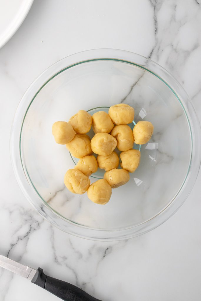 balls of struffoli dough in a glass mixing bowl