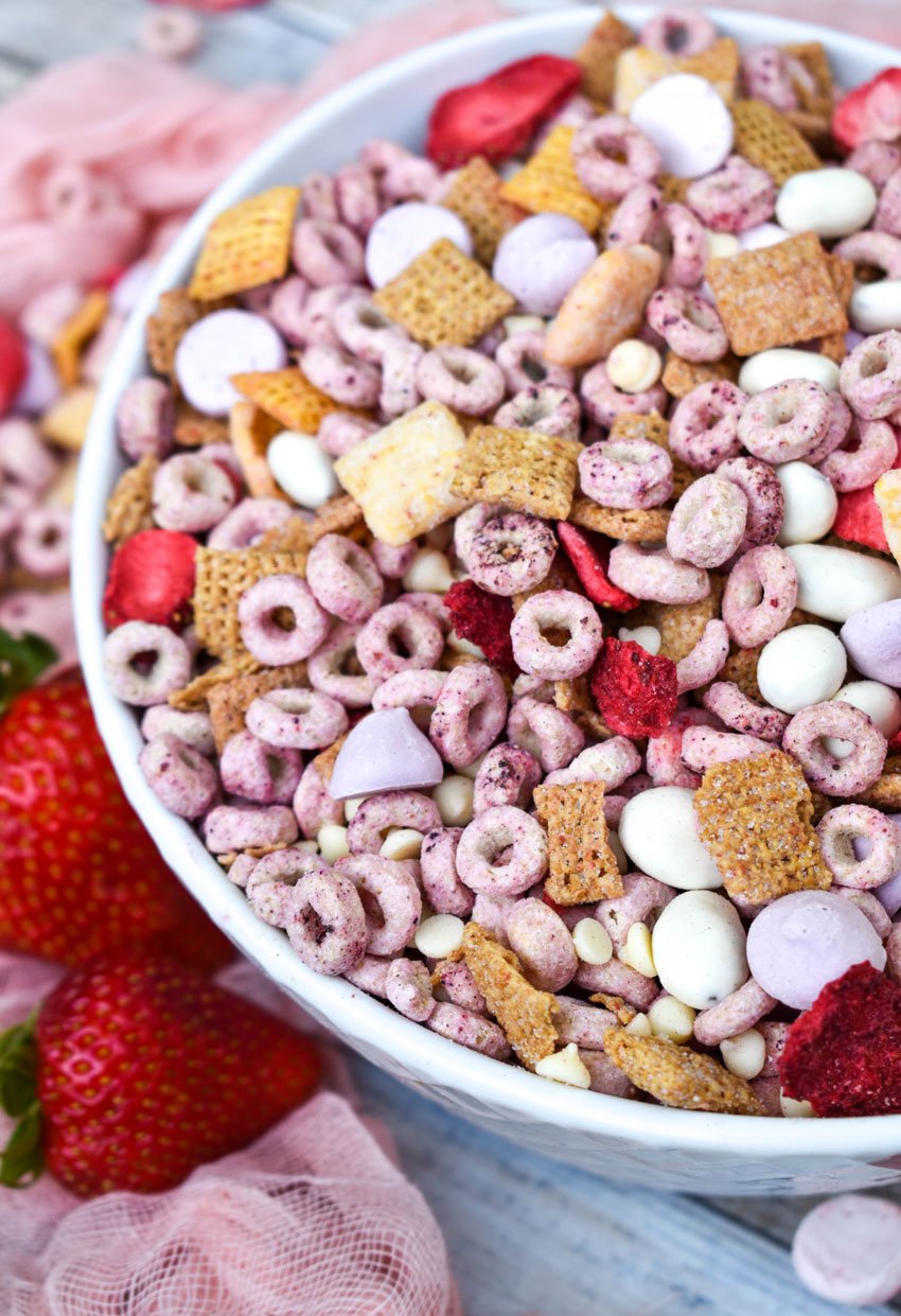 the viral strawberry snack mix from tiktok shown in a white bowl with fresh strawberries on the side
