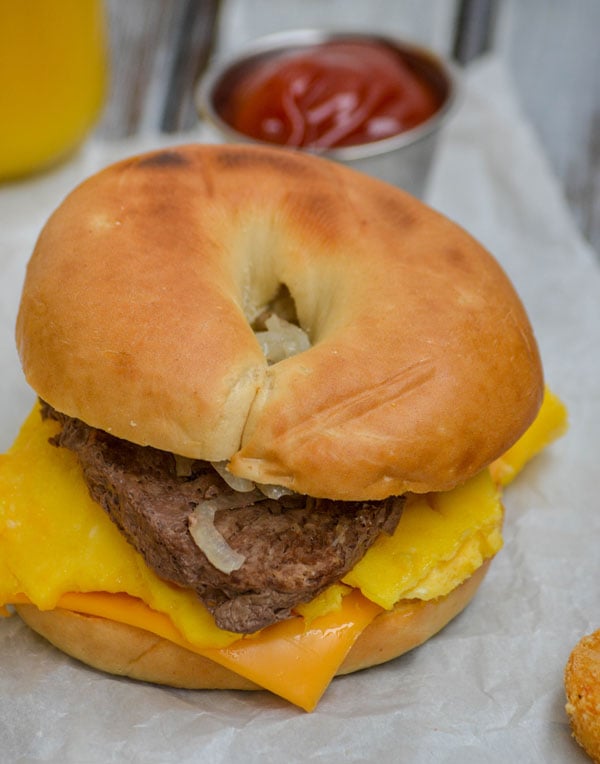 a copycat mcdonald's steak egg and cheese bagel on parchment paper