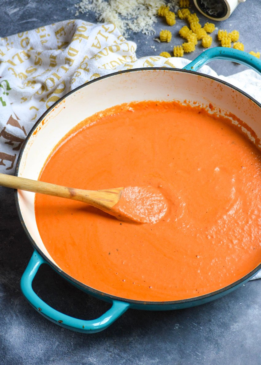 quick and easy vodka sauce in a shallow sauce pan with a wooden spoon on the side
