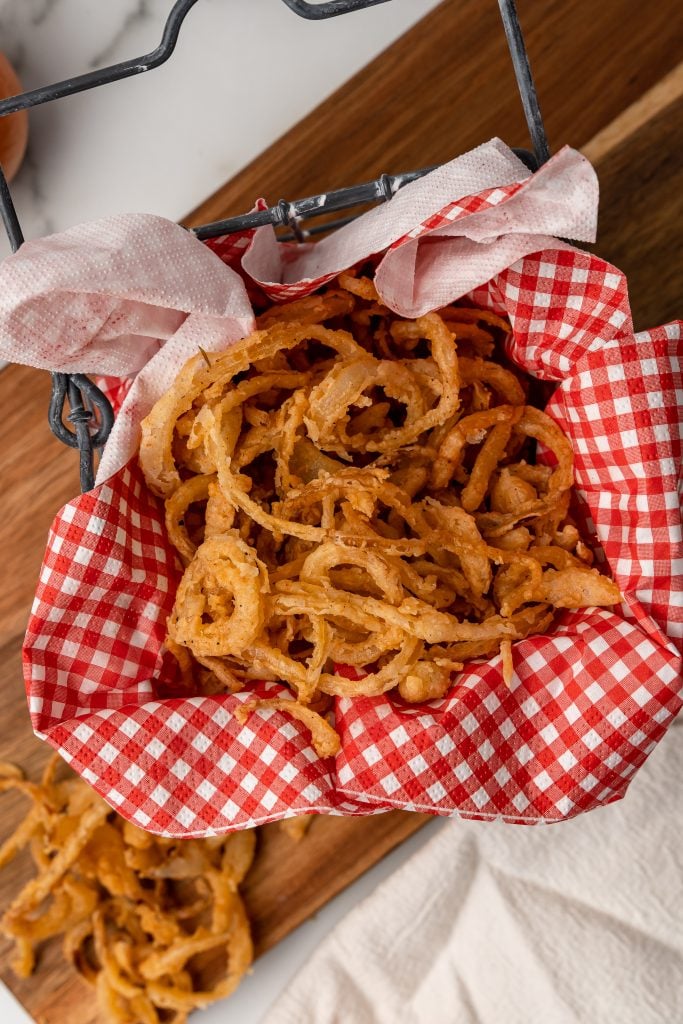 fried crispy onion straws in a red paper lined basked