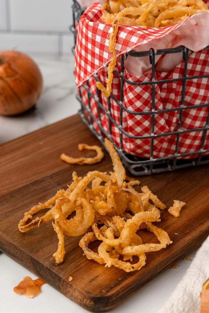 homemade french fried onions on a wooden cutting board
