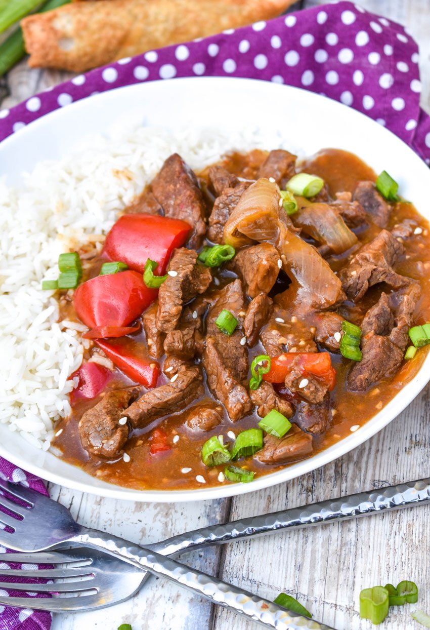 Instant pot beijing beef over steamed white rice in a shallow white bowl