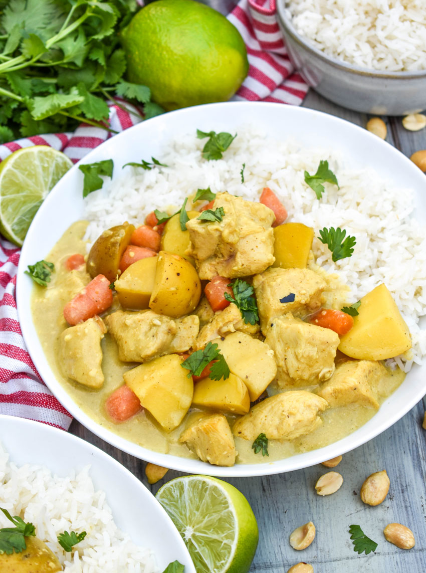 slow cooker chicken curry over white rice in a shallow white bowl