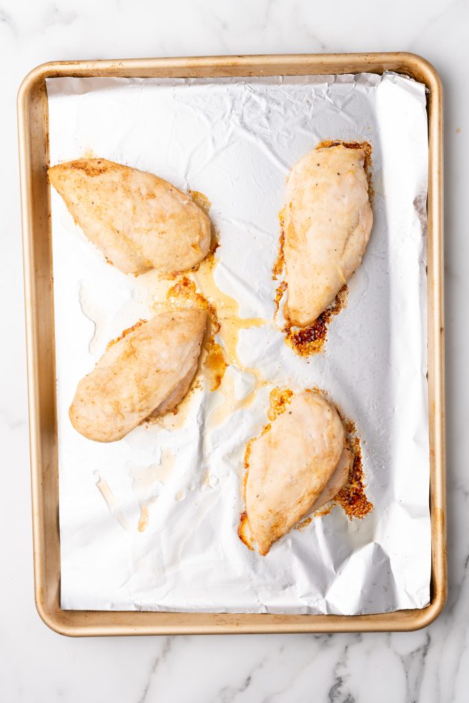 baked chicken breasts on a foil lined baking sheet