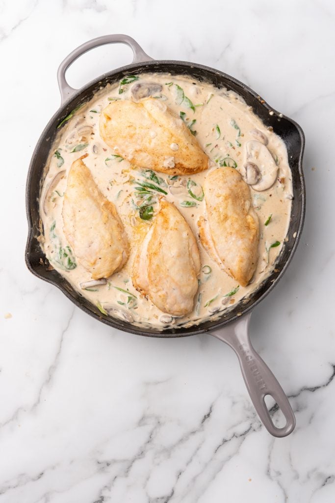 champagne chicken in cream sauce in a large black skillet