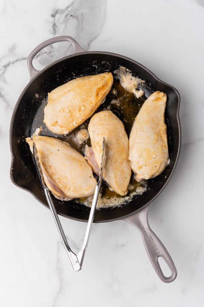 seaerd chicken breasts in a black skillet