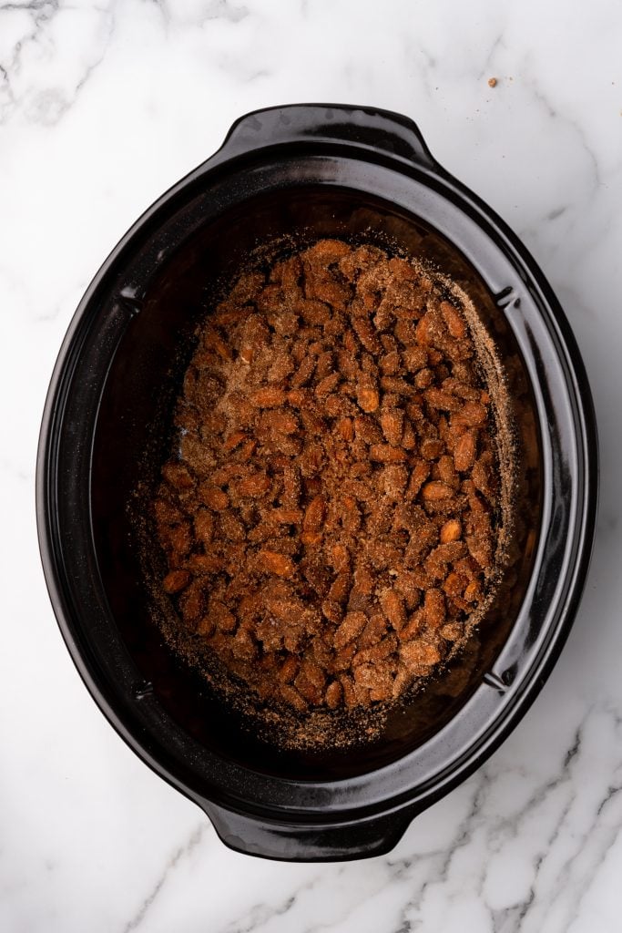 cinnamon sugar almonds in the black bowl of a slow cooker