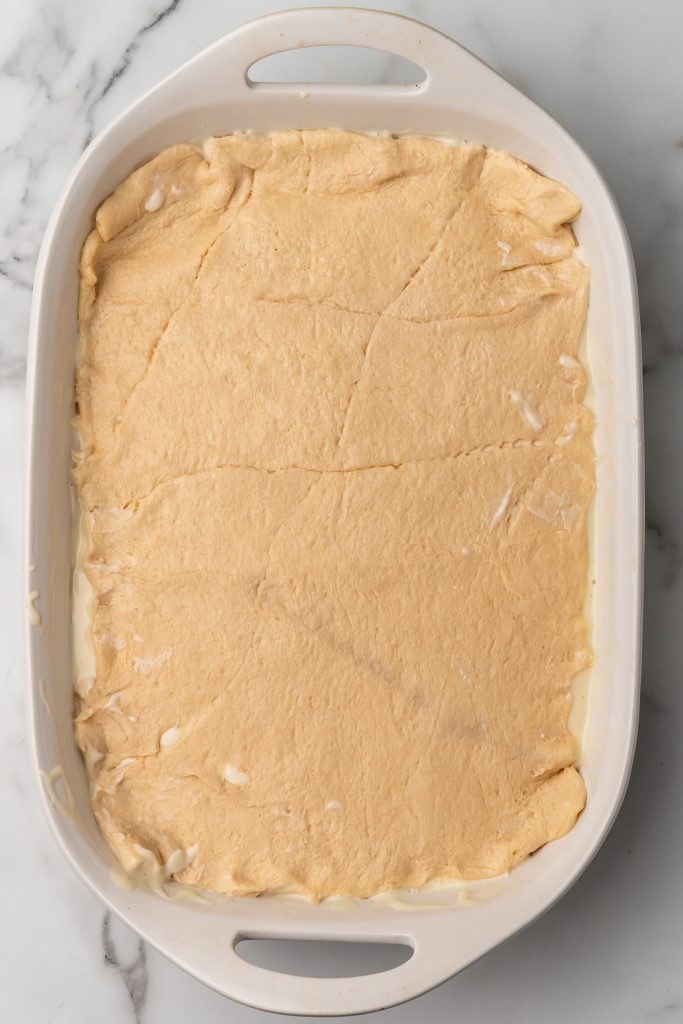 layered crescent roll cheesecake in a white baking dish