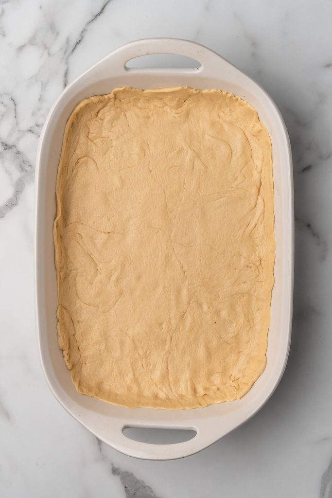 a layer of crescent roll dough pressed into the bottom of a casserole dish