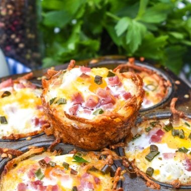 cheesy hashbrown nests in a dark metal muffin pan