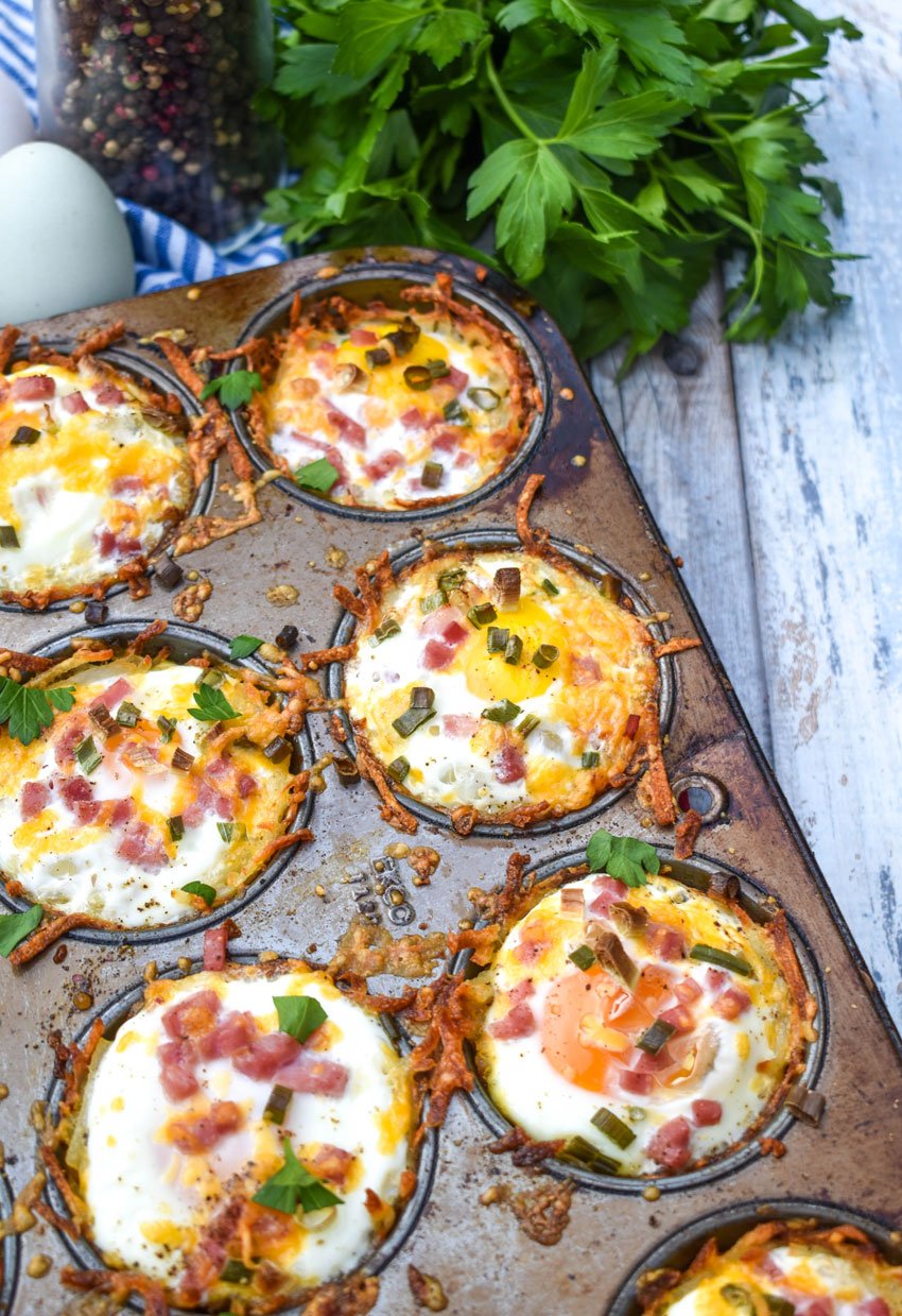 hashbrown nests in a metal muffin pan on a wooden table