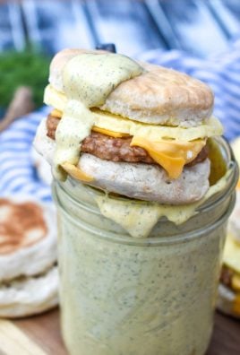 a breakfast sandwich resting on the edge of a glass jar topped with creamy mcdonald's sauce