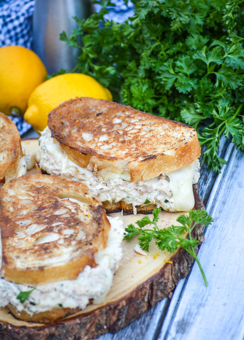 cheesy tuna melt sandwiches on toasted sourdough sitting on a wooden cutting board