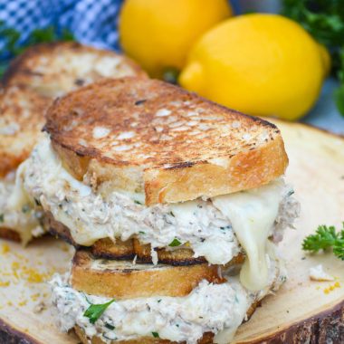 two of the best tuna melts stacked together on as wooden cutting board