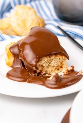 grandma's chocolate gravy recipe poured over biscuits on a white plate