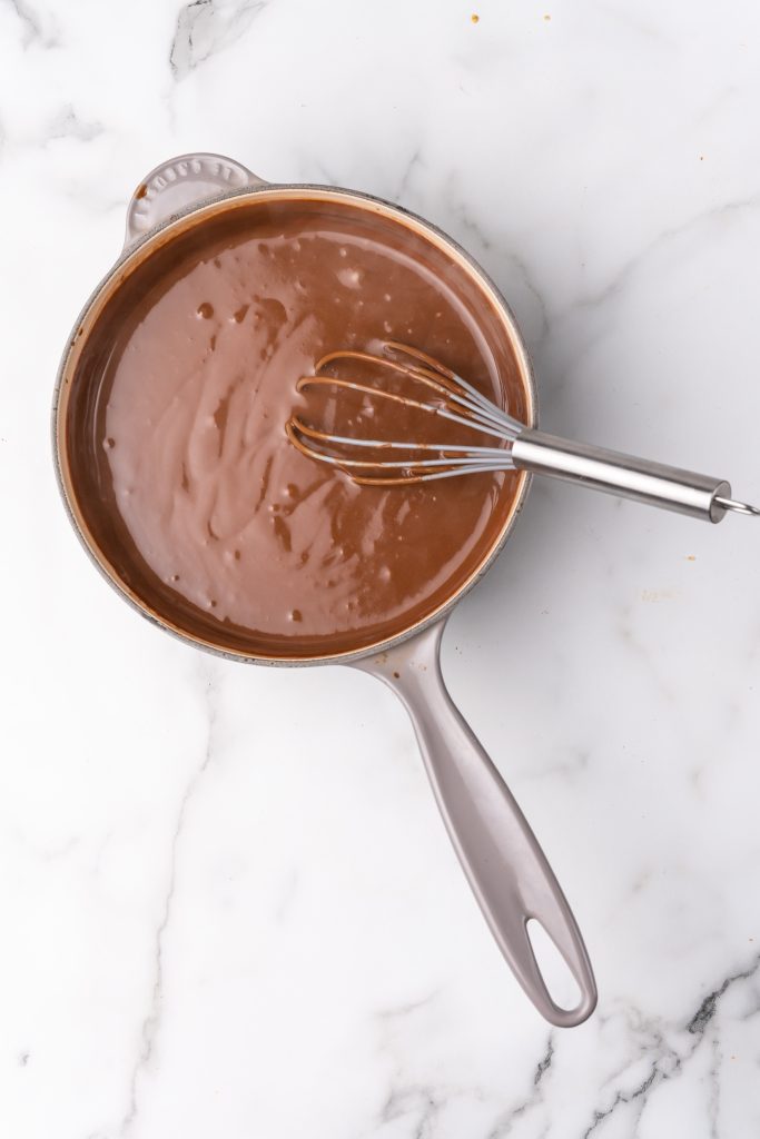 southern chocolate gravy and a wire whisk in a gray sauce pan