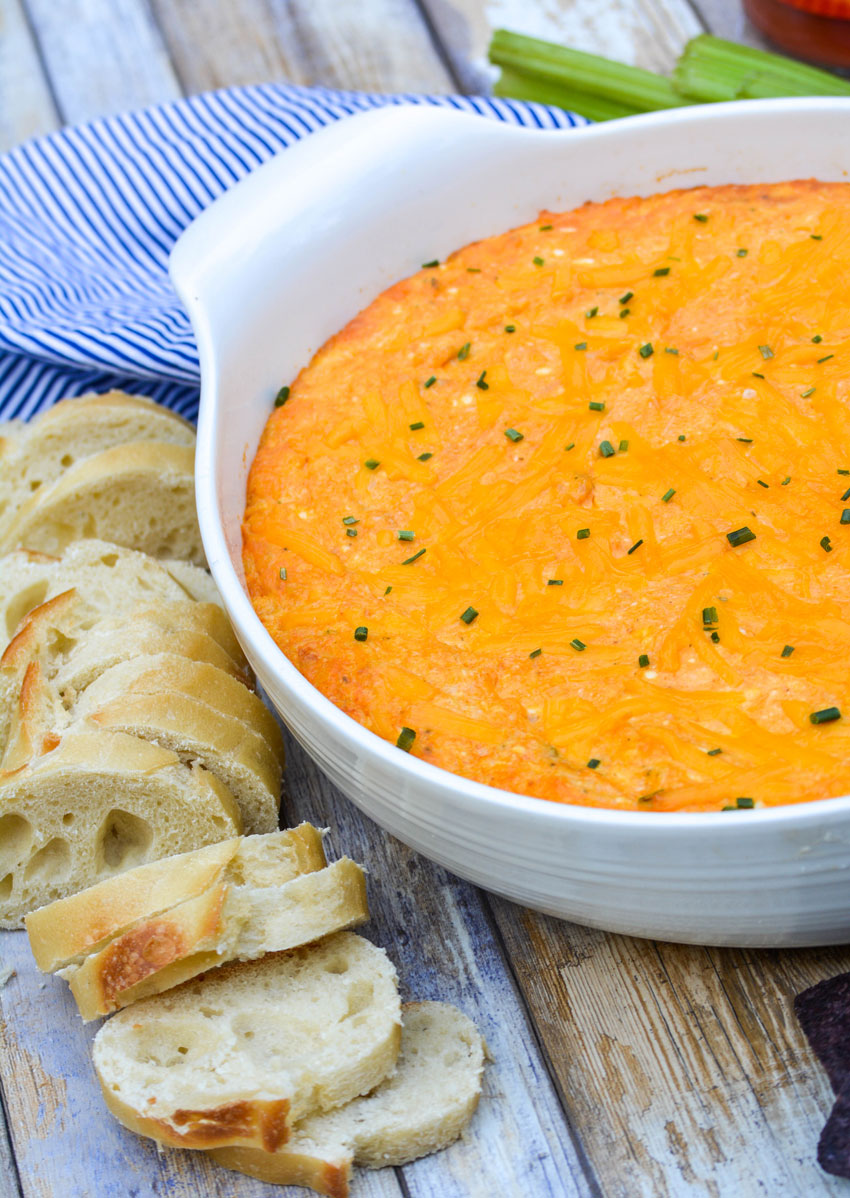 cheesy buffalo chicken dip in a white serving bowl