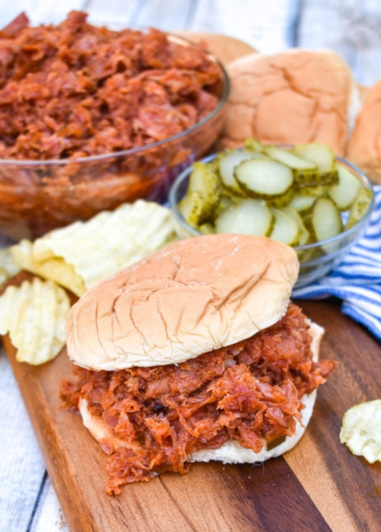 Pittsburgh Chipped Ham Barbecue on a fluffy hamburger bun on a wooden cutting board