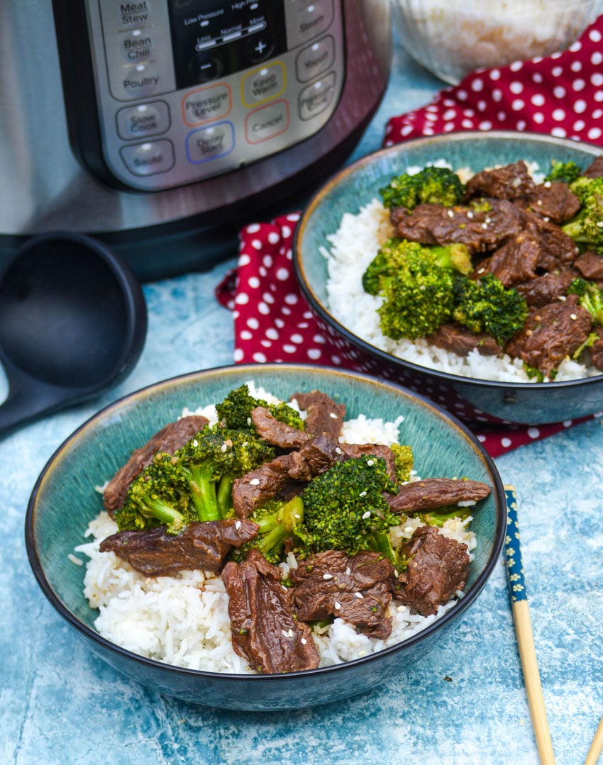 two green bowls filled with instant pot beef and broccoli over steamed rice