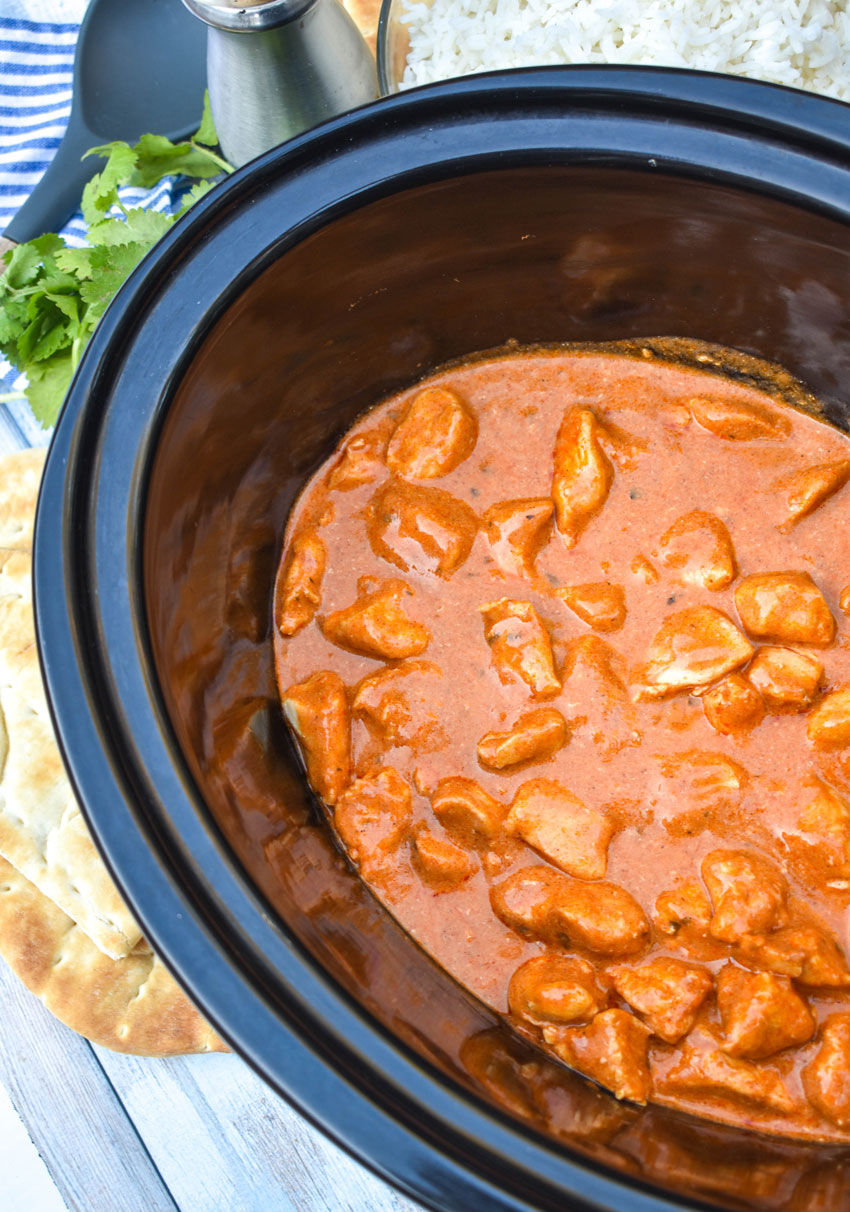 easy butter chicken in the black bowl of a crockpot