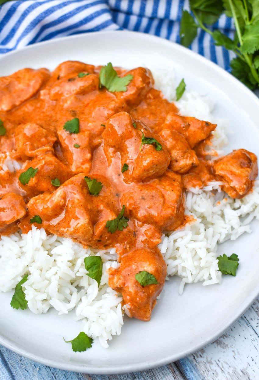 crockpot butter chicken over white rice on a white plate