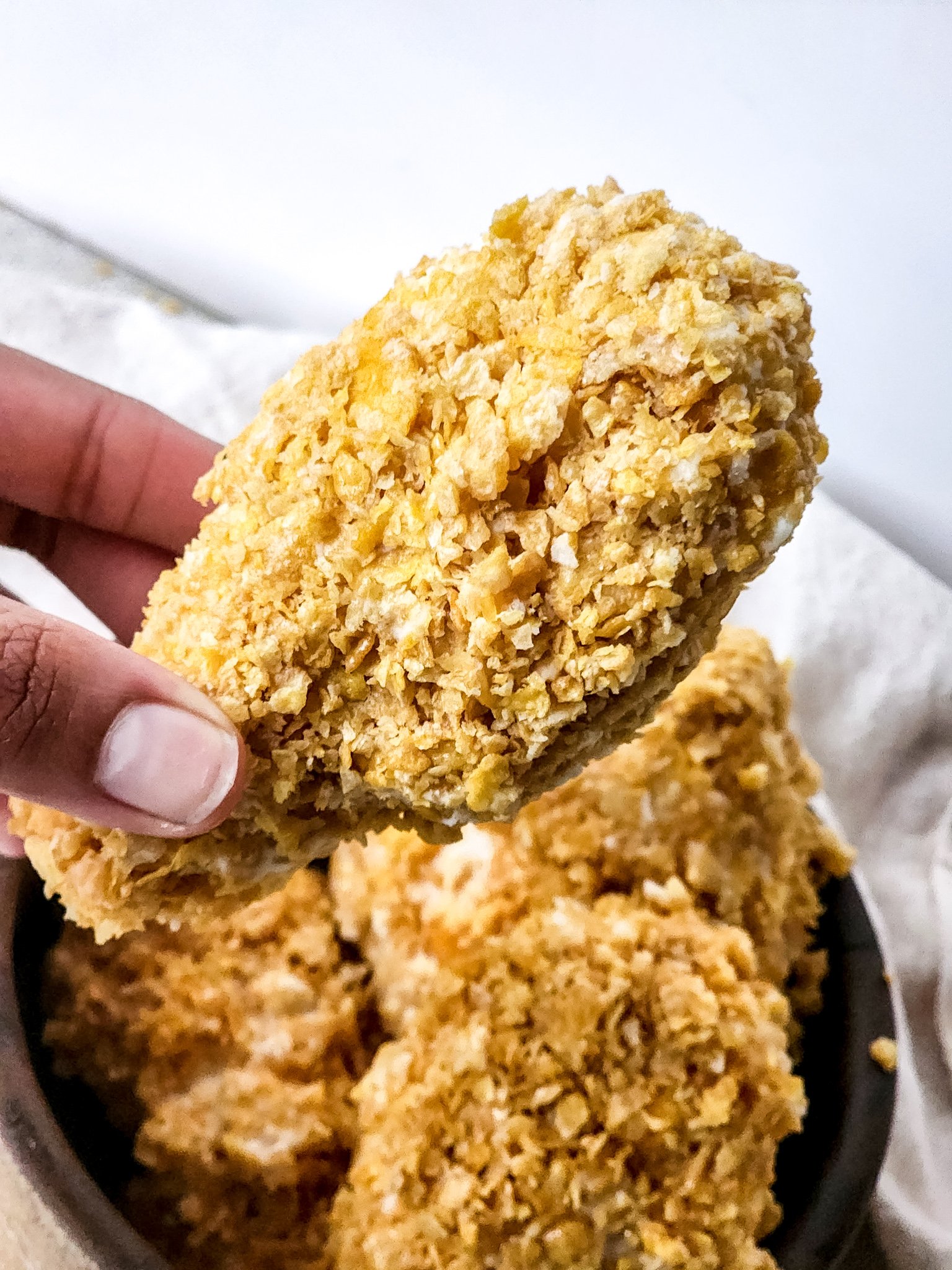 a hand holding up a piece of fried chicken ice cream