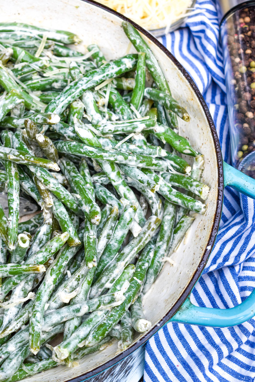 green beans with caesar dressing in a blue skillet
