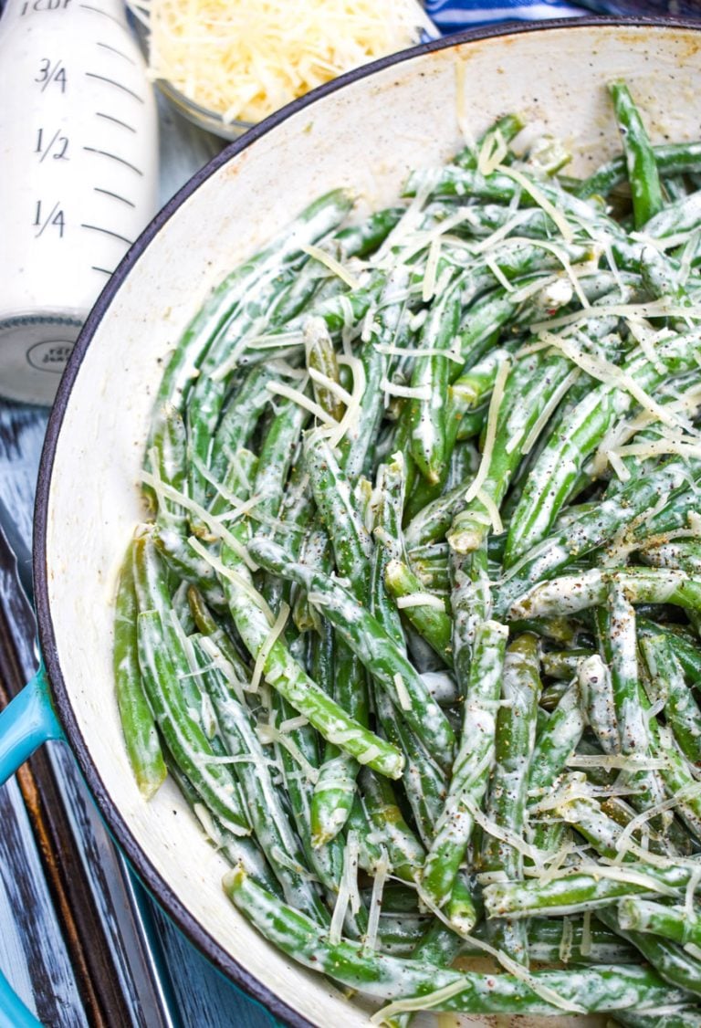 creamy caesar green beans in a blue cast iron skillet