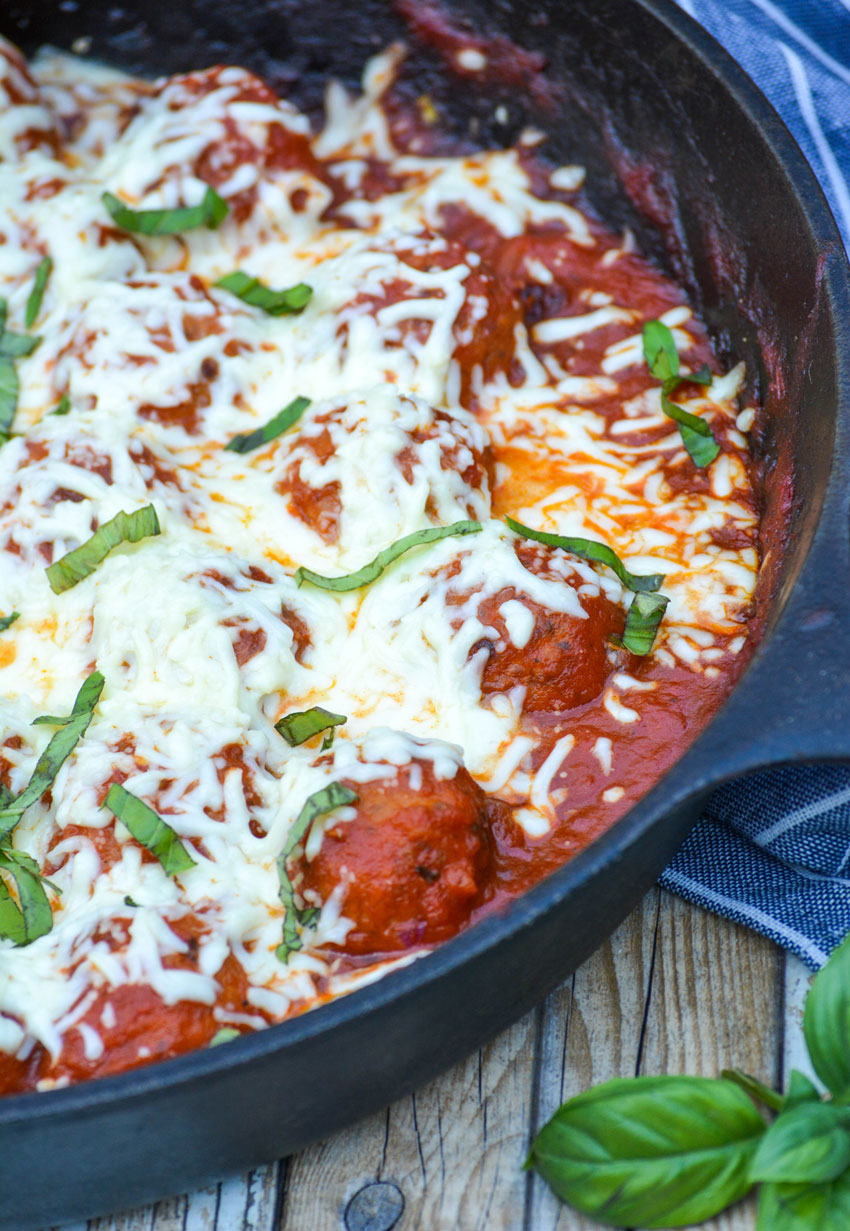a meatball parmesan skillet in a black cast iron skillet